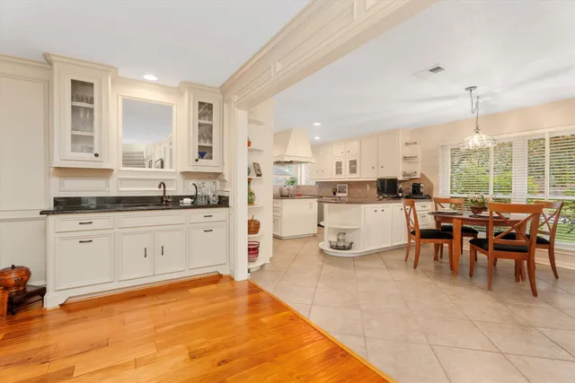 a large white kitchen with lots of counter top space and dining table