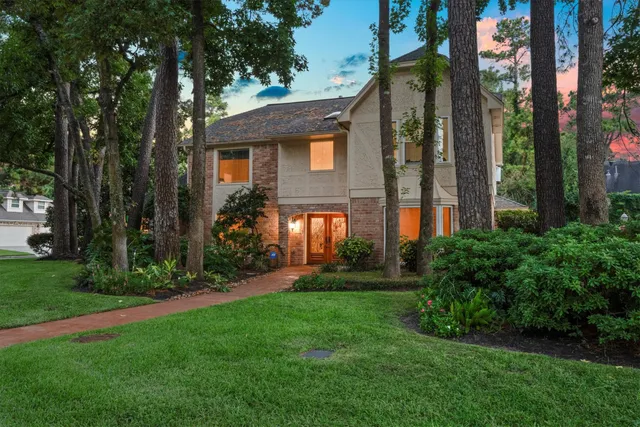 a front view of a house with a yard and trees