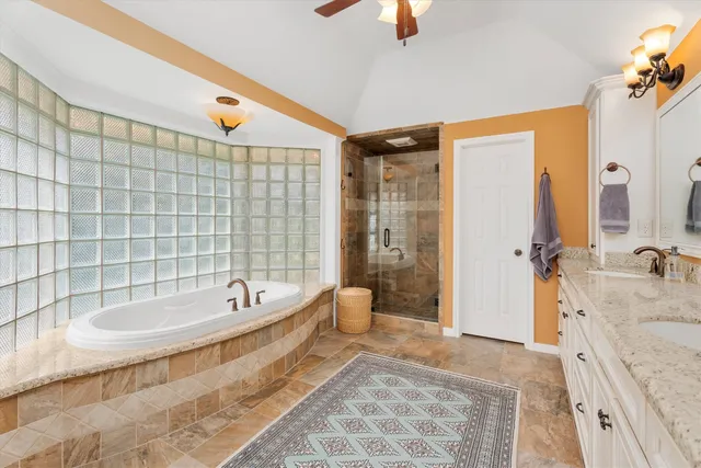 a spacious bathroom with a tub sink and mirror