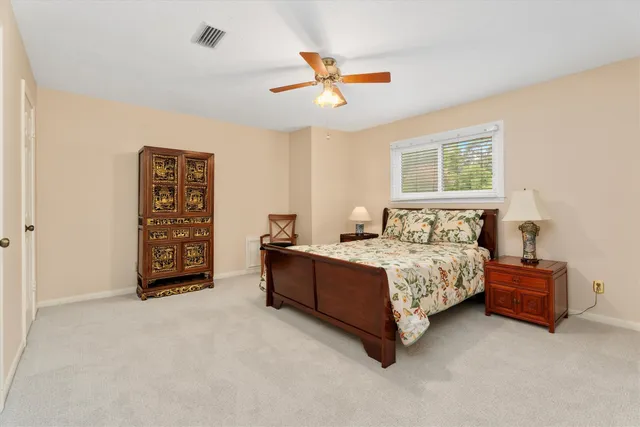 a spacious bedroom with a bed and a ceiling fan