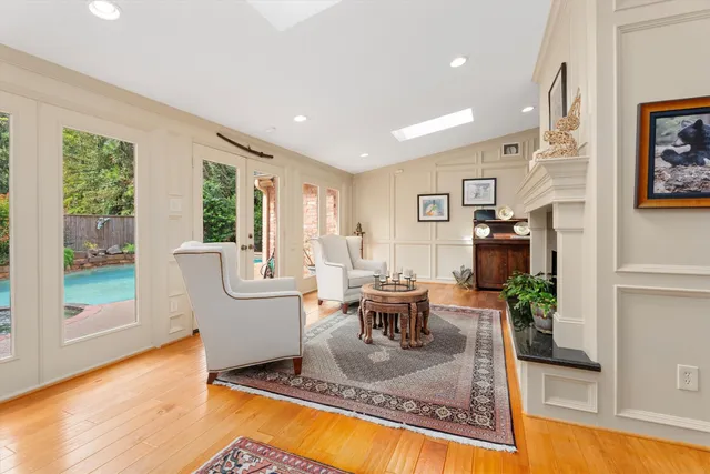 a living room with fireplace furniture and a large window