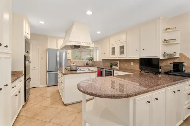 a kitchen with stainless steel appliances granite countertop a sink refrigerator and cabinets