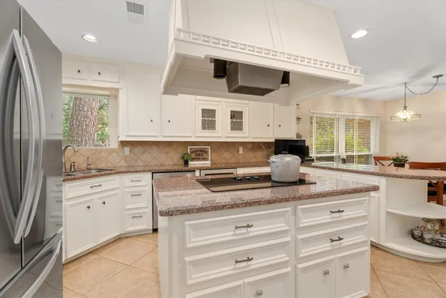 a kitchen with granite countertop white cabinets and white appliances