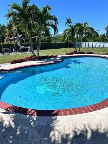 a view of a swimming pool with an outdoor space and seating area