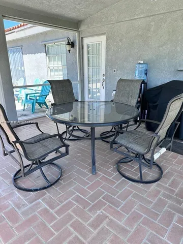 a living room with patio furniture and a floor to ceiling window