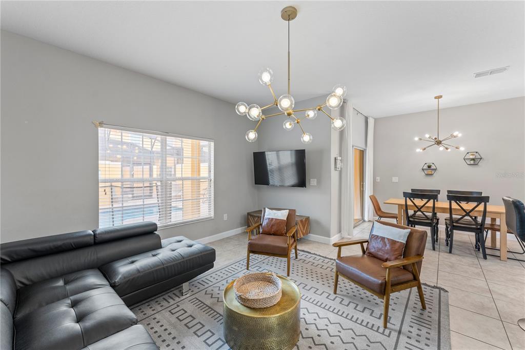 8955 Bismarck Palm Road Kissimmee, FL 34747 - Photo 11 of 32 a living room with furniture and a chandelier