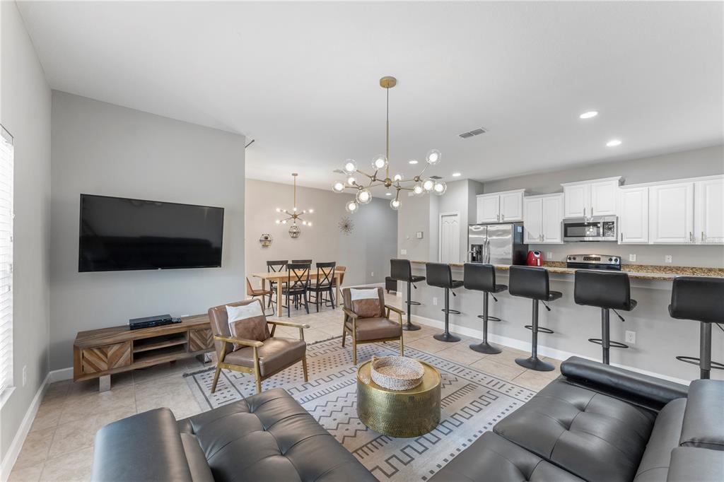 8955 Bismarck Palm Road Kissimmee, FL 34747 - Photo 12 of 32 a living room with furniture and a flat screen tv