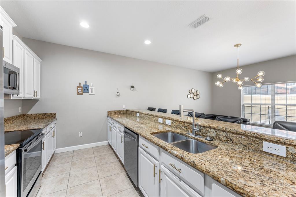 8955 Bismarck Palm Road Kissimmee, FL 34747 - Photo 14 of 32 a kitchen with a sink stove and cabinets
