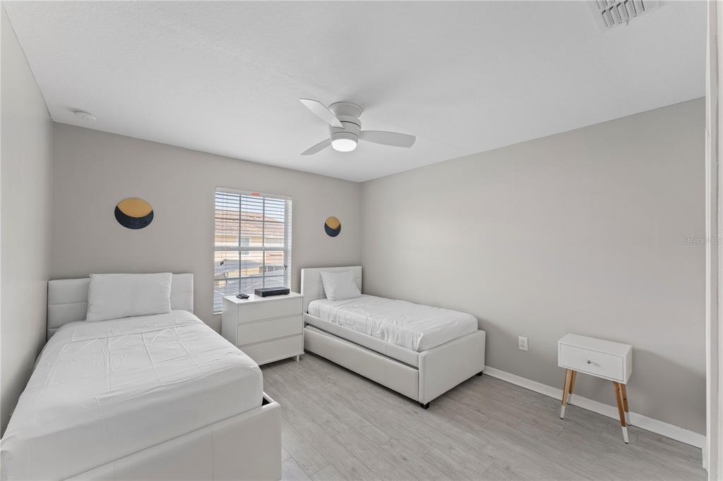 8955 Bismarck Palm Road Kissimmee, FL 34747 - Photo 18 of 32 a bedroom with two beds and a chair