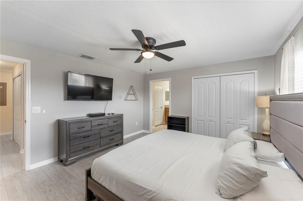 8955 Bismarck Palm Road Kissimmee, FL 34747 - Photo 24 of 32 a bedroom with a bed a dresser and a flat screen tv