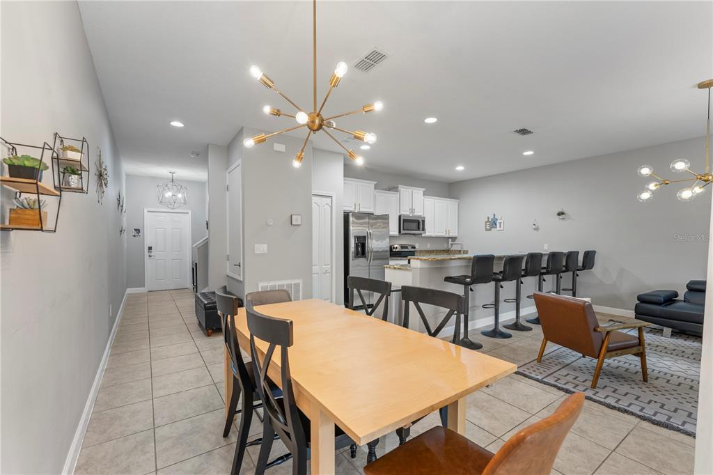8955 Bismarck Palm Road Kissimmee, FL 34747 - Photo 8 of 32 a dining room with stainless steel appliances kitchen island a table and chairs