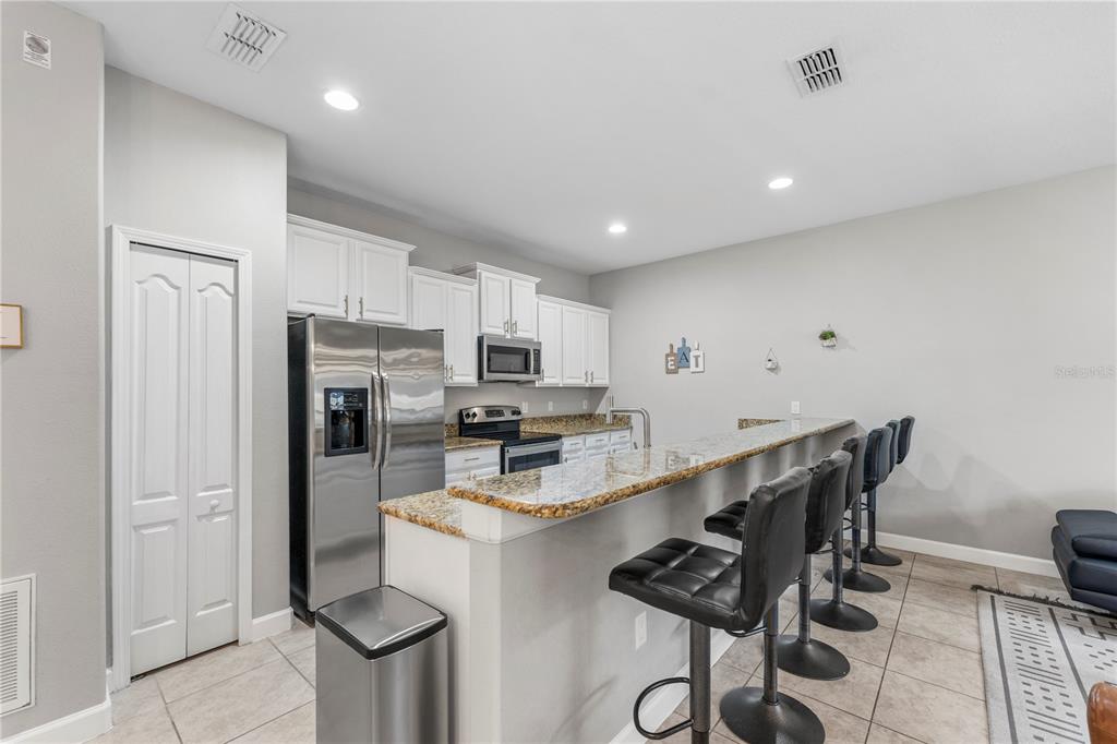 8955 Bismarck Palm Road Kissimmee, FL 34747 - Photo 10 of 32 a kitchen with stainless steel appliances a refrigerator and microwave