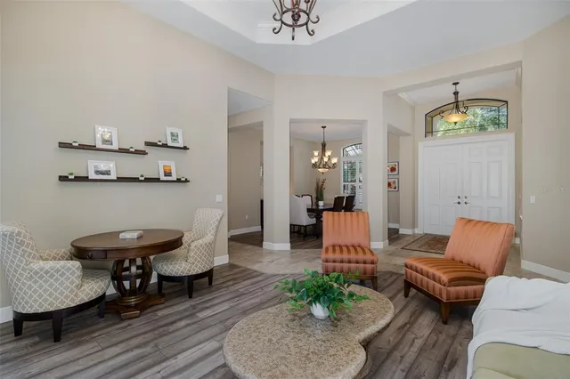 a view of a dining room with furniture a chandelier and wooden floor