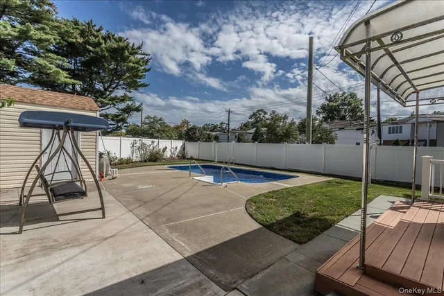 a swimming pool view with a seating space and a garden