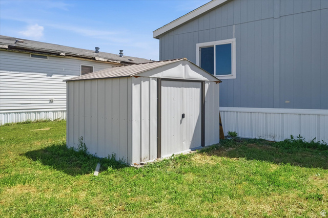 433 North 750 West Logan, UT 84321 - Photo 30 of 40 Freestanding metal storage shed with a peaked roof, positioned on a grass lawn