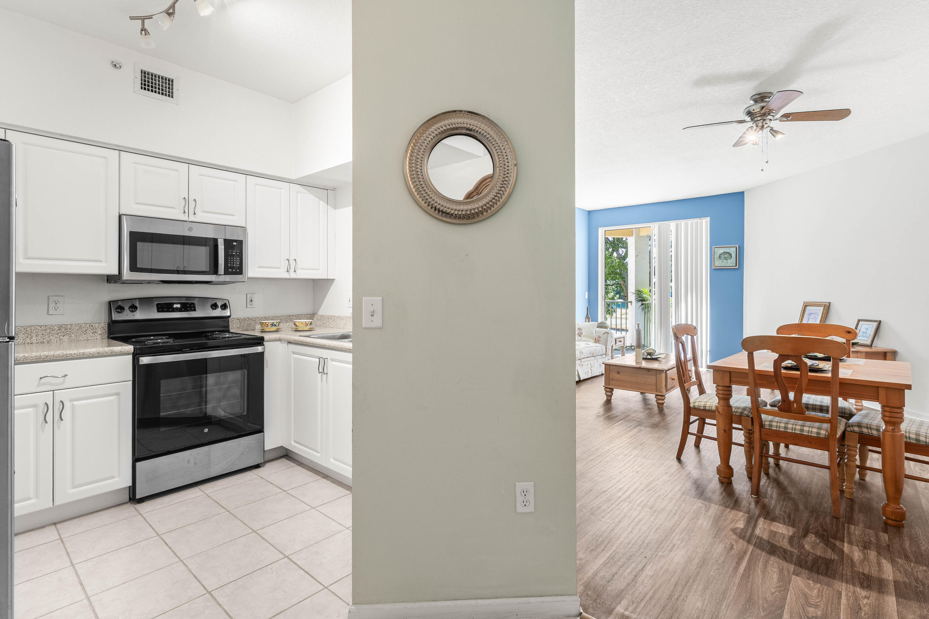 a kitchen with stainless steel appliances a stove top oven a sink a dining table and chairs
