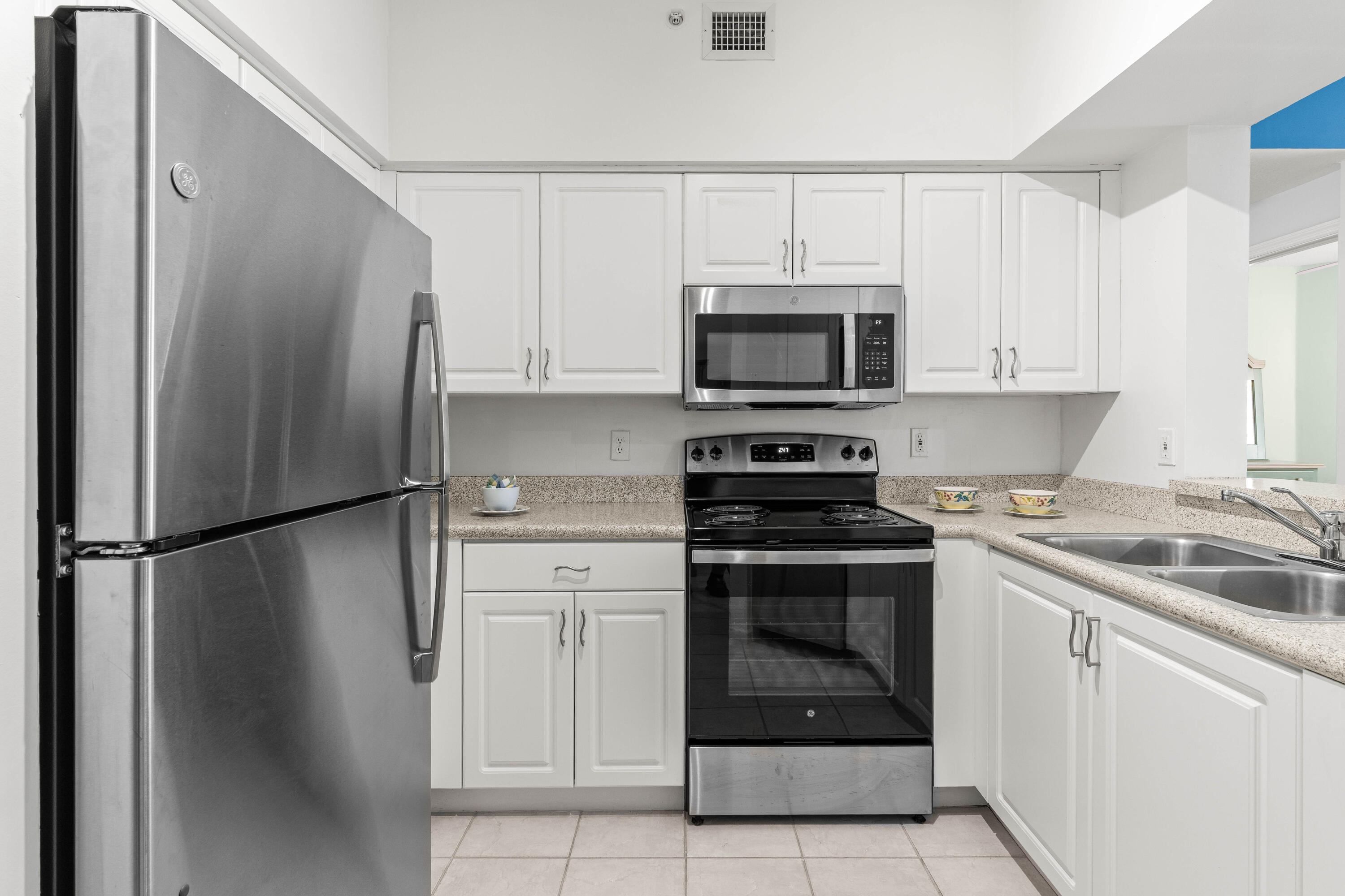 1951 Brandywine Road, Unit 207 West Palm Beach, FL 33409 - Photo 2 of 45 a kitchen with white cabinets and stainless steel appliances