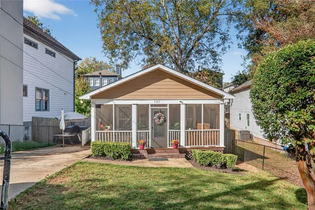 a front view of a house with a yard and potted plants