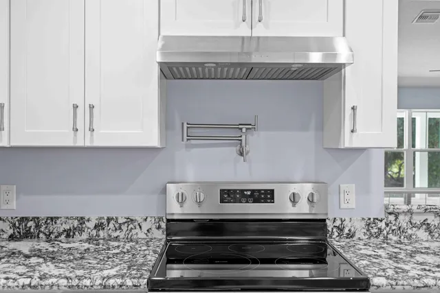 a large kitchen with kitchen island granite countertop a sink and cabinets