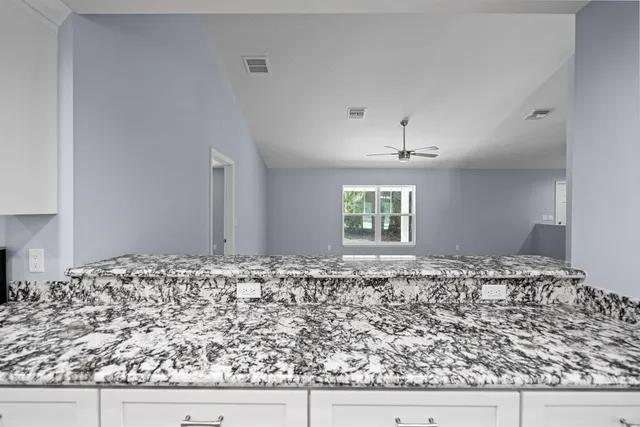 an empty room with a window and a fan