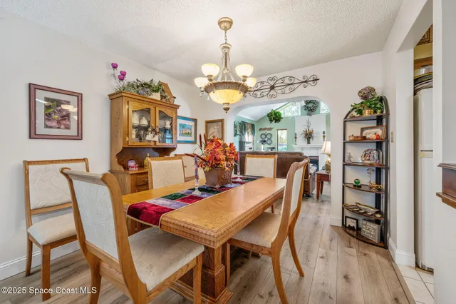 a view of a dining room with furniture a chandelier and wooden floor