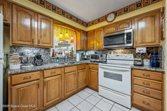 a kitchen with granite countertop cabinets stainless steel appliances a sink and a window