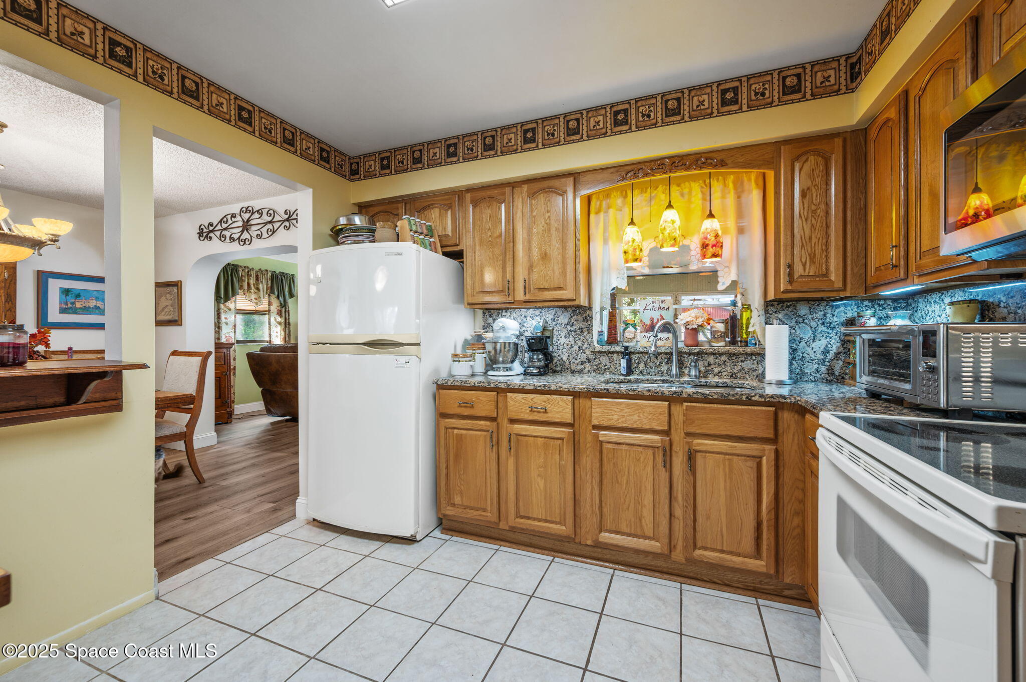 5220 Holden Road Cocoa, FL 32927 - Photo 19 of 31 a kitchen with stainless steel appliances granite countertop a refrigerator and a stove top oven