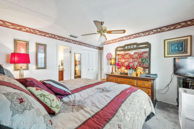 a bedroom with a bed and a flat screen tv on dresser