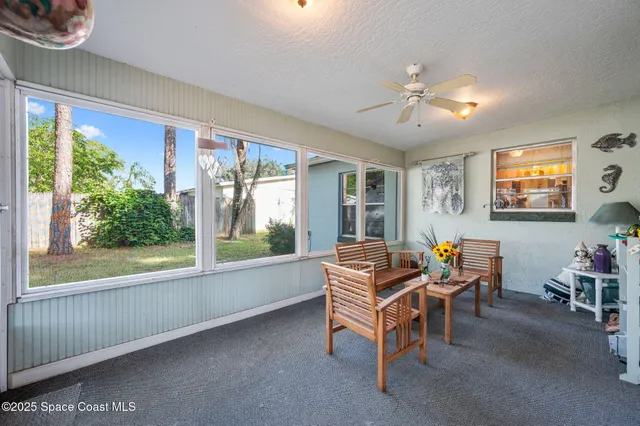 a living room with furniture and a floor to ceiling window