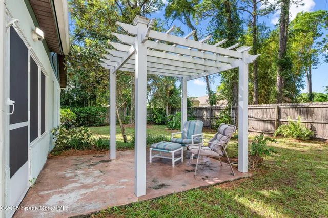 a view of a patio with a table chairs and a backyard