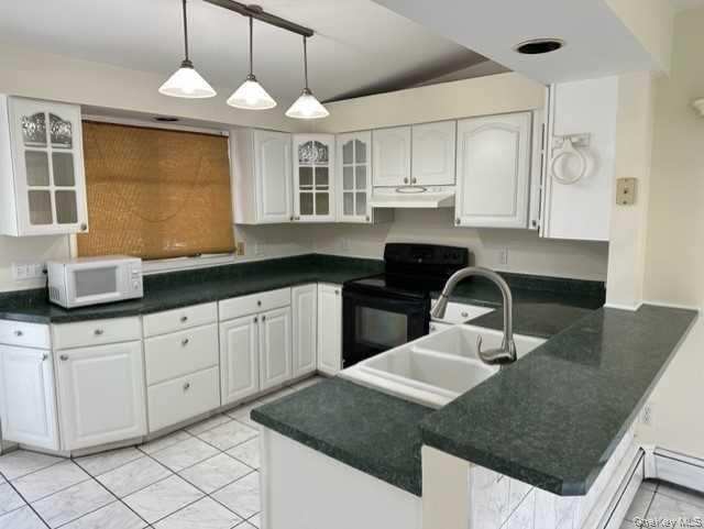 131 Spackenkill Road Poughkeepsie, NY 12603 - Photo 3 of 14 a kitchen with a sink dishwasher a stove a microwave oven with white cabinets and wooden floor