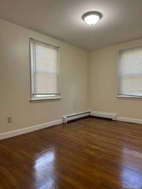 131 Spackenkill Road Poughkeepsie, NY 12603 - Photo 7 of 14 an empty room with wooden floor and windows