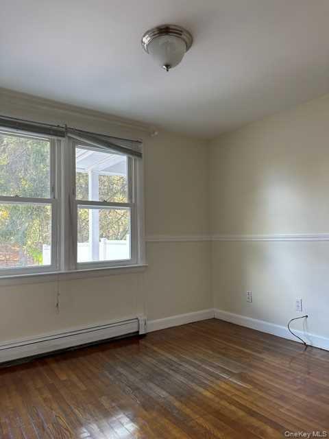 131 Spackenkill Road Poughkeepsie, NY 12603 - Photo 8 of 14 an empty room with wooden floor and windows