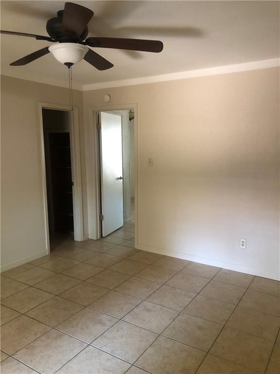 7007 Guadalupe Street, Unit 1 Austin, TX 78752 - Photo 5 of 8 Unfurnished room featuring a ceiling fan, light tile patterned flooring, and crown molding