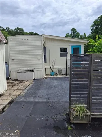 a view of a house with backyard and a tree