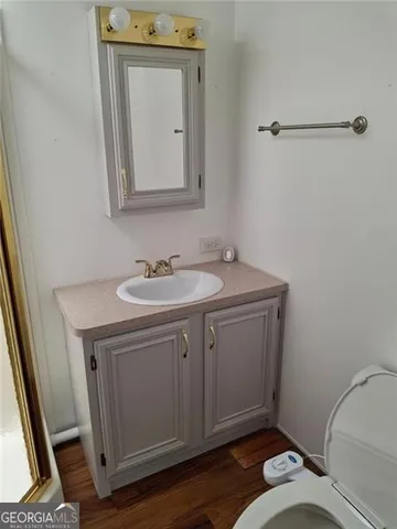 a bathroom with a sink toilet and mirror