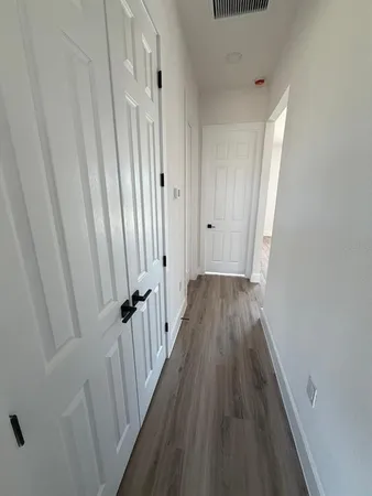 a view of a hallway with wooden floor