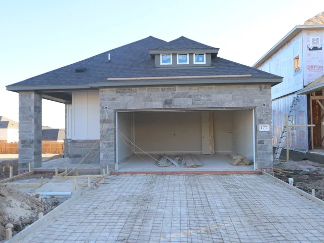 a view of a house with a yard and large tree