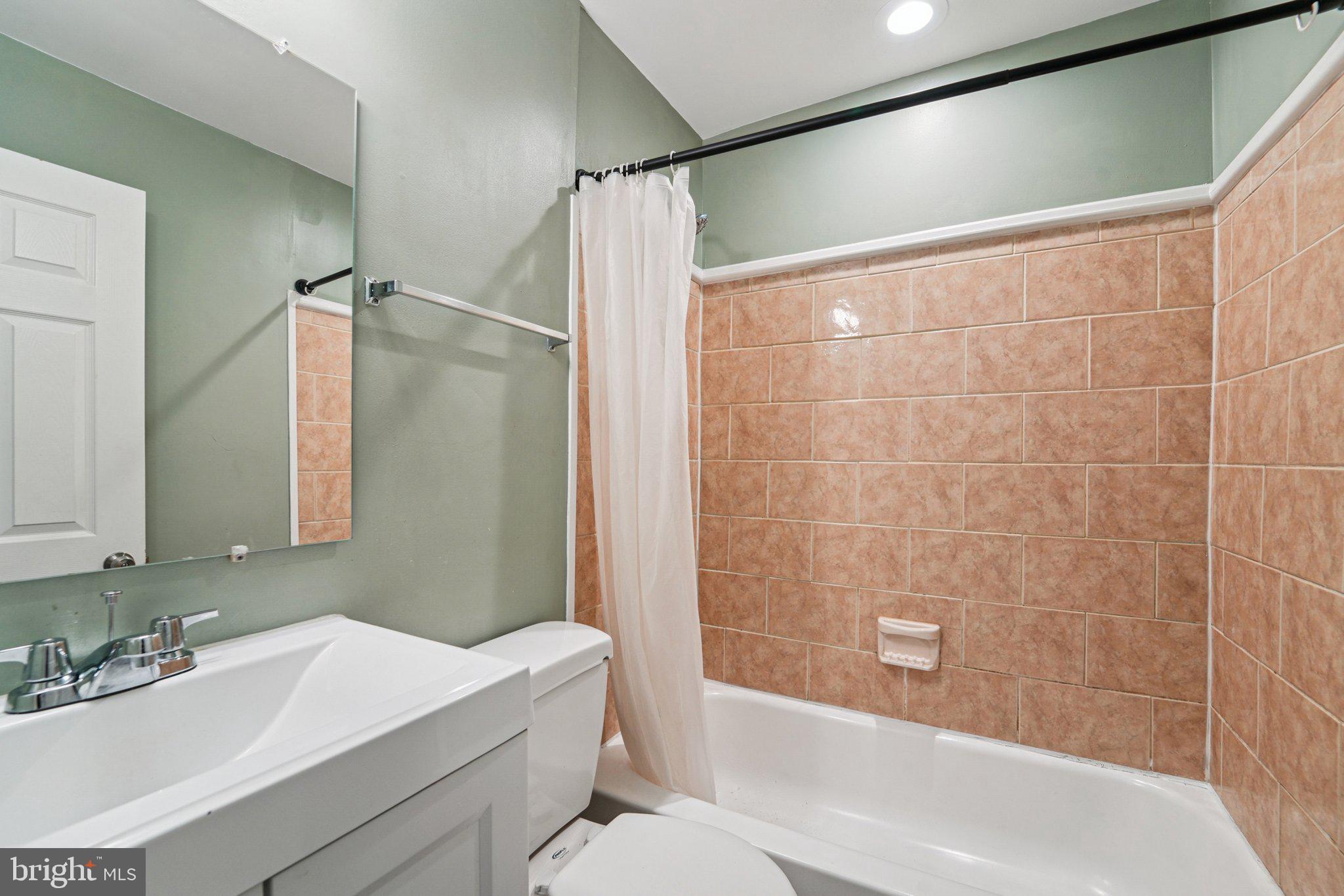 1820 East Lafayette Avenue Baltimore, MD 21213 - Photo 12 of 17 a bathroom with a sink mirror toilet and bathtub