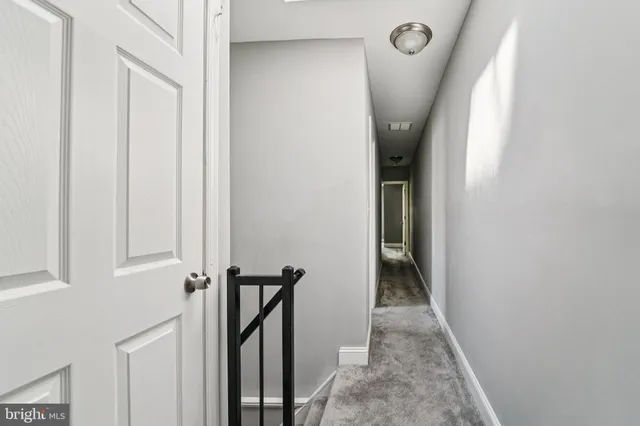 a view of a hallway with wooden floor and entryway