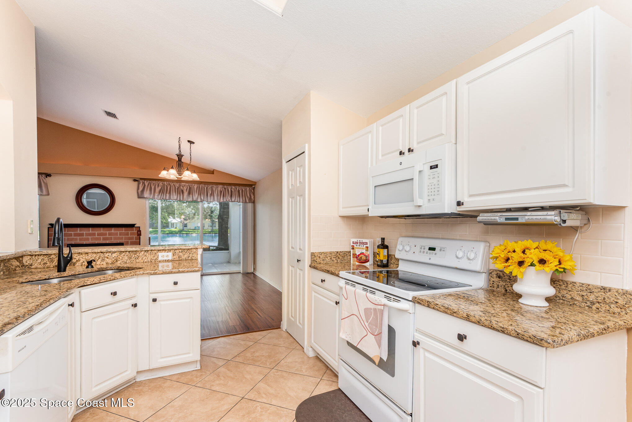 2597 Addington Circle Rockledge, FL 32955 - Photo 11 of 28 a kitchen with granite countertop white cabinets and white appliances