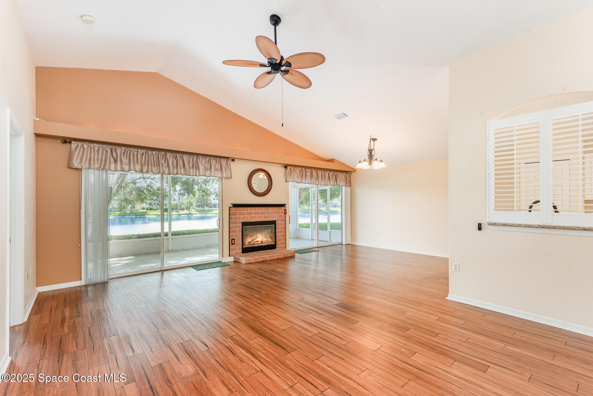 2597 Addington Circle Rockledge, FL 32955 - Photo 5 of 28 an empty room with wooden floor fan and windows