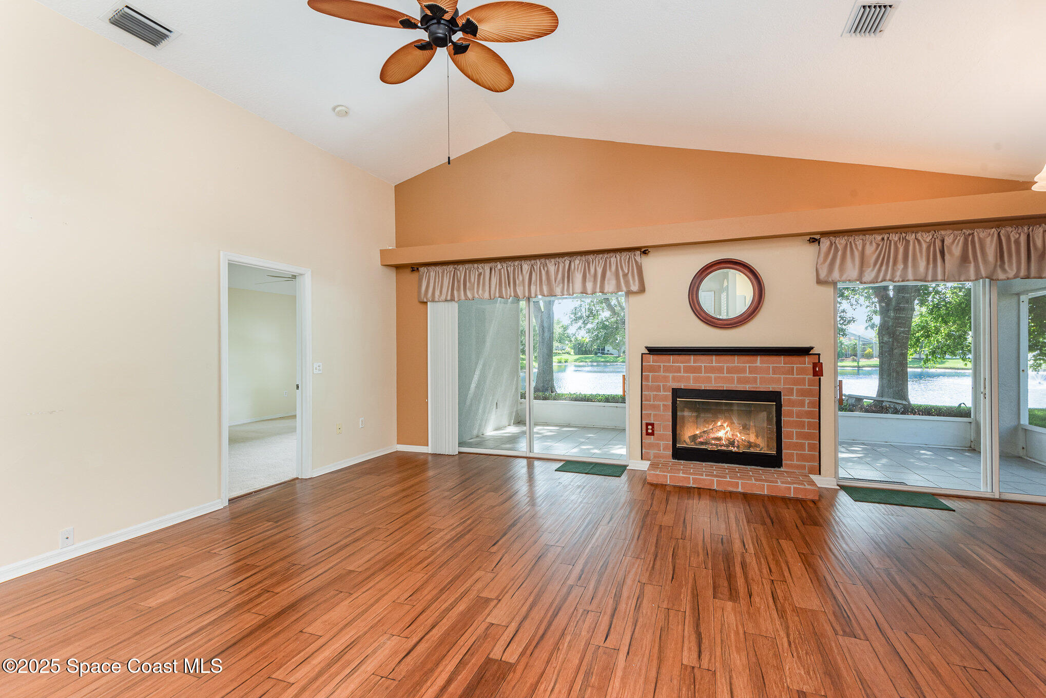 2597 Addington Circle Rockledge, FL 32955 - Photo 6 of 28 a view of an empty room with wooden floor fireplace and a window