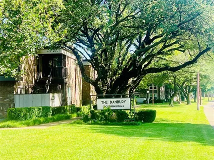 a view of a house with a big yard and large trees