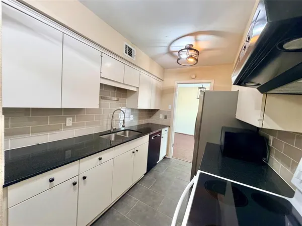 a kitchen with stainless steel appliances granite countertop a sink and a stove