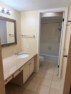 a bathroom with a granite countertop sink a toilet and shower