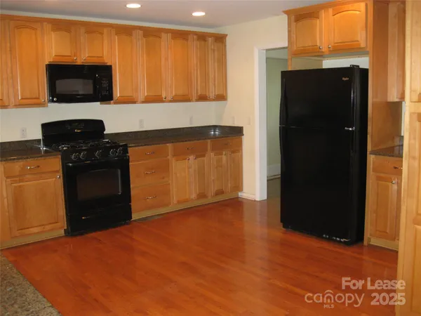 a kitchen with stainless steel appliances granite countertop a refrigerator and a stove top oven