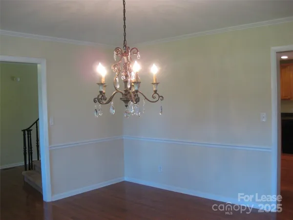 a view of a room with wooden floor and chandelier