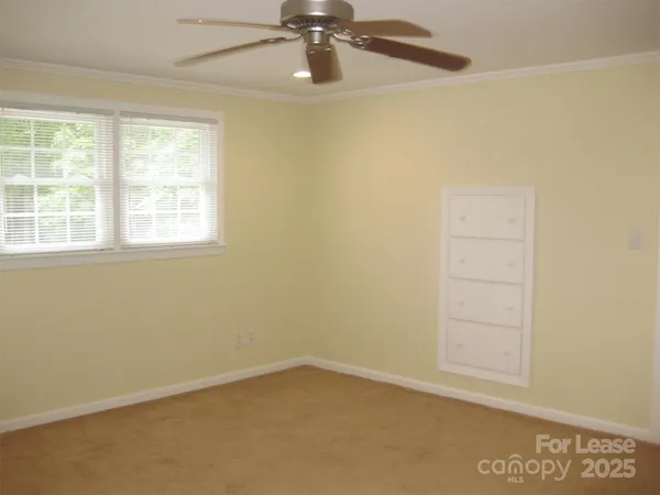 an empty room with a window and a ceiling fan