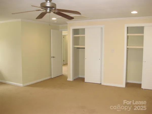 en empty room with windows and ceiling fan